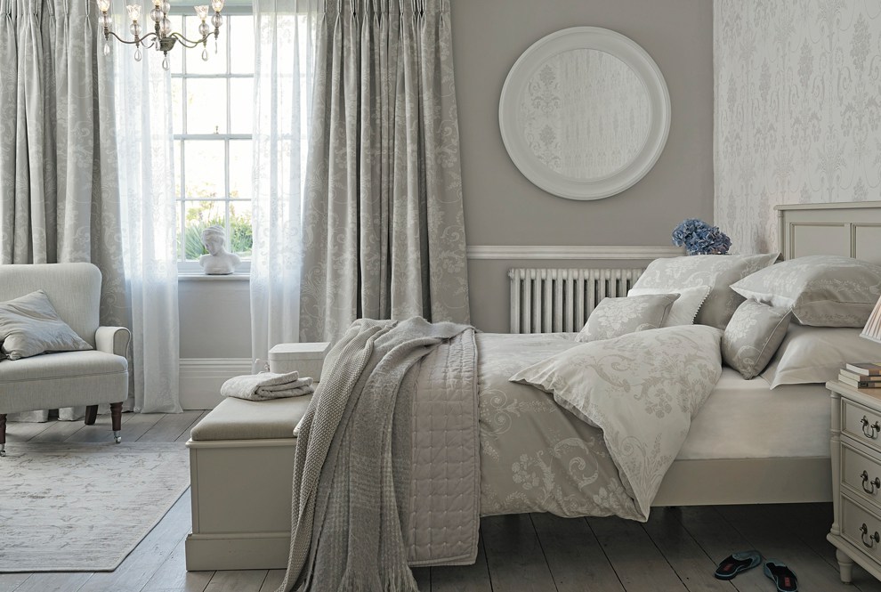 neutral-toned bedroom with upholstered bed, soft textiles, and natural light.